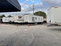 MegaWattage Warehouse Parking Lot Lined Up With Large Trailers Holding Commercial Generators.